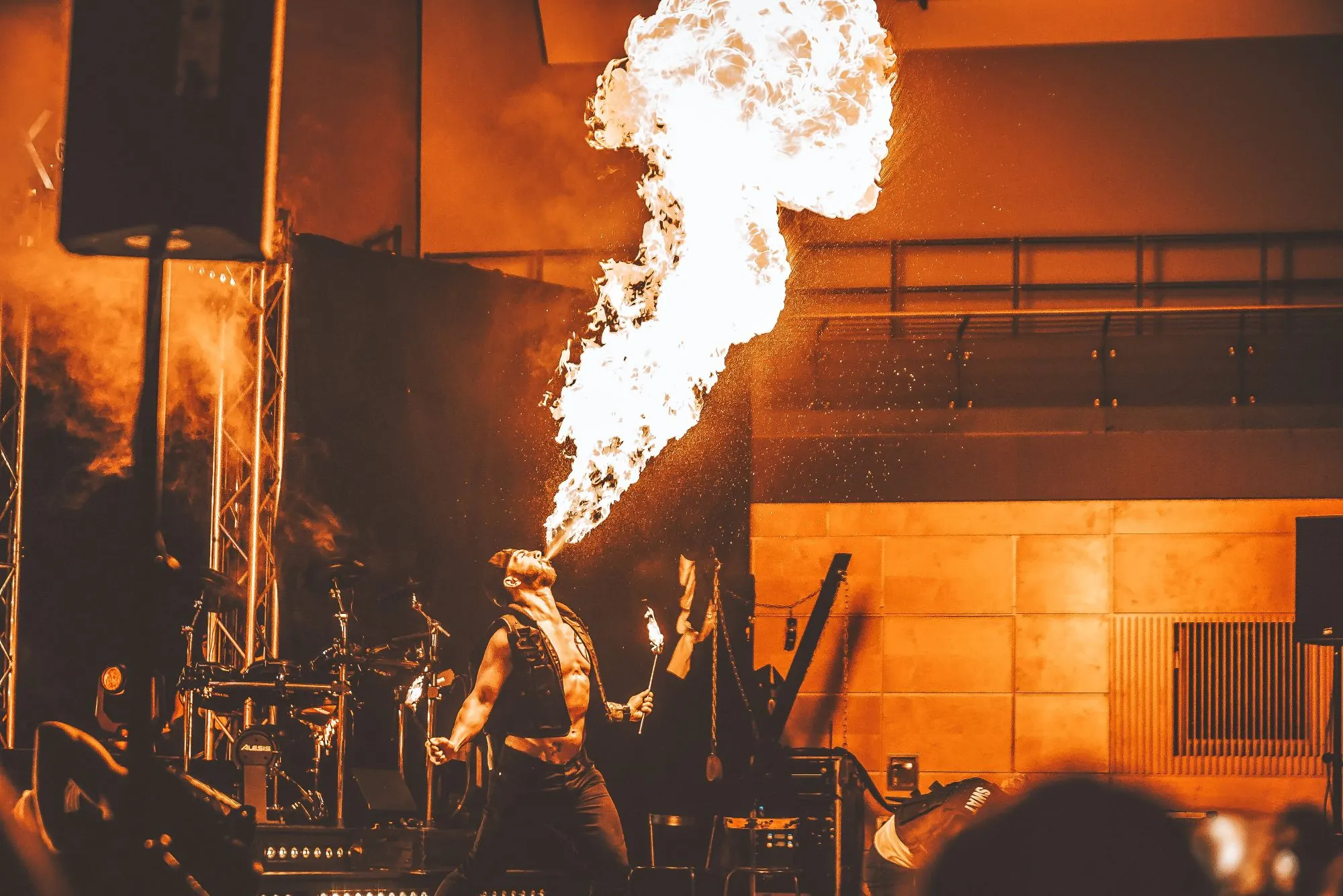 Feuerspucker erzeugt auf einer Bühne eine meterhohe Stichflamme