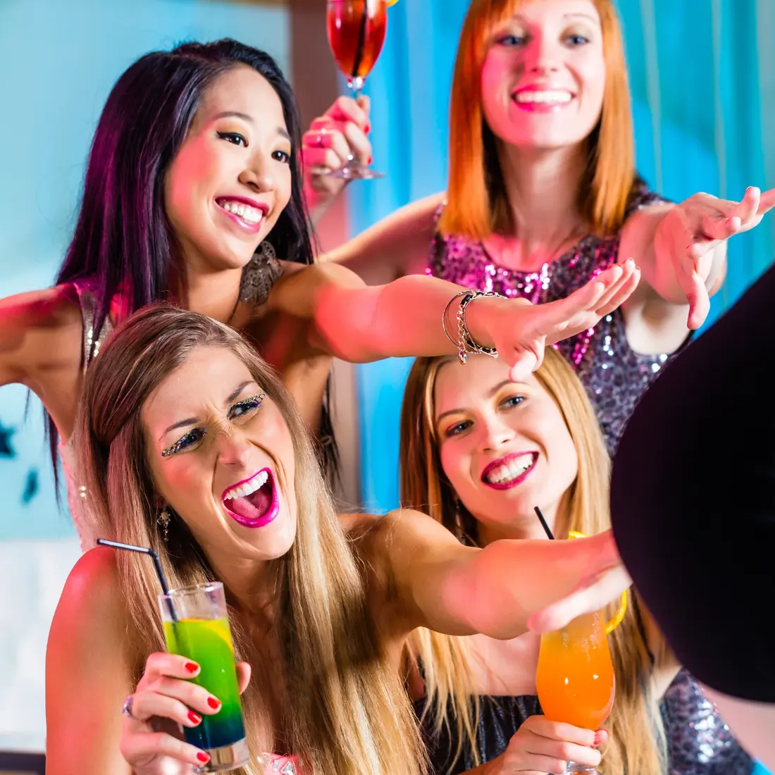Ausgelassene Frauenrunde mit Cocktails feiert eine Stripshow zum Geburtstag
