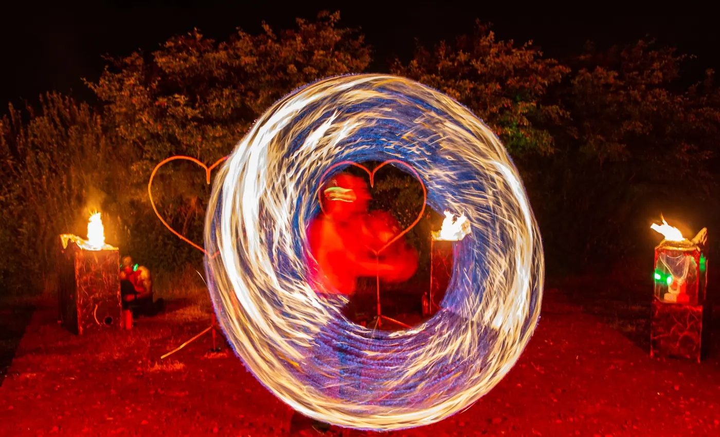 Feuerkreis mit Lichtspuren vor einem Flammenherz
